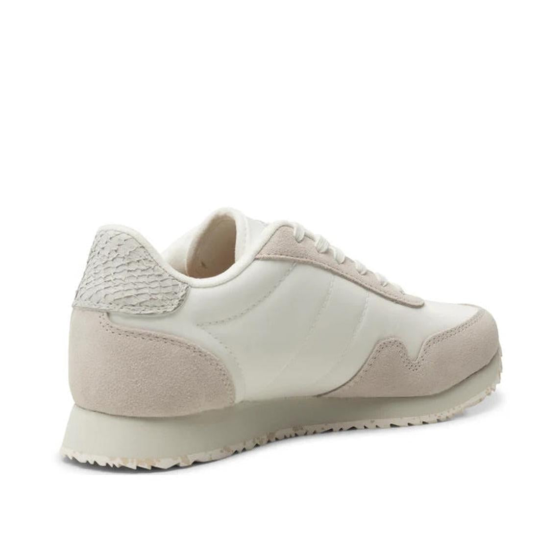 The Woden Womens Sneaker Nora III Nylon/Leather Blanc de Blanc, shown from the back left, features a textured heel, lace-up closure, and ridged rubber sole—ideal for anyone seeking stylish urban footwear., 5713326428360, 5713326428377, 5713326428384, 5713