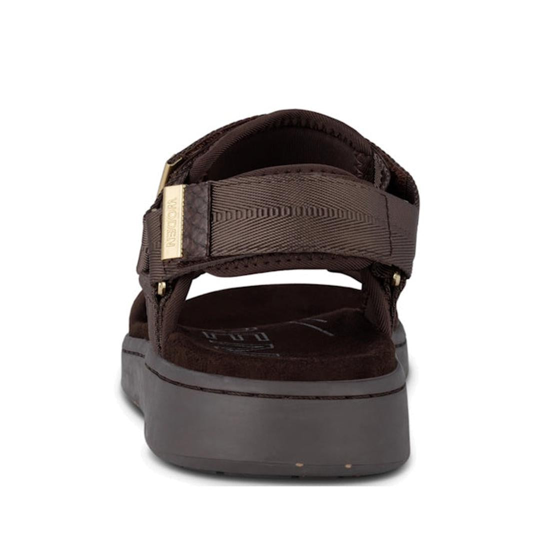 Rear view of the Woden Line Women's 3 Strap Sandal in chocolate brown, featuring adjustable straps, a thick sole with Natural Soft technology, and a fabric label on the left heel strap, set against a white background., 48196, 5713326592511, 5713326592528,